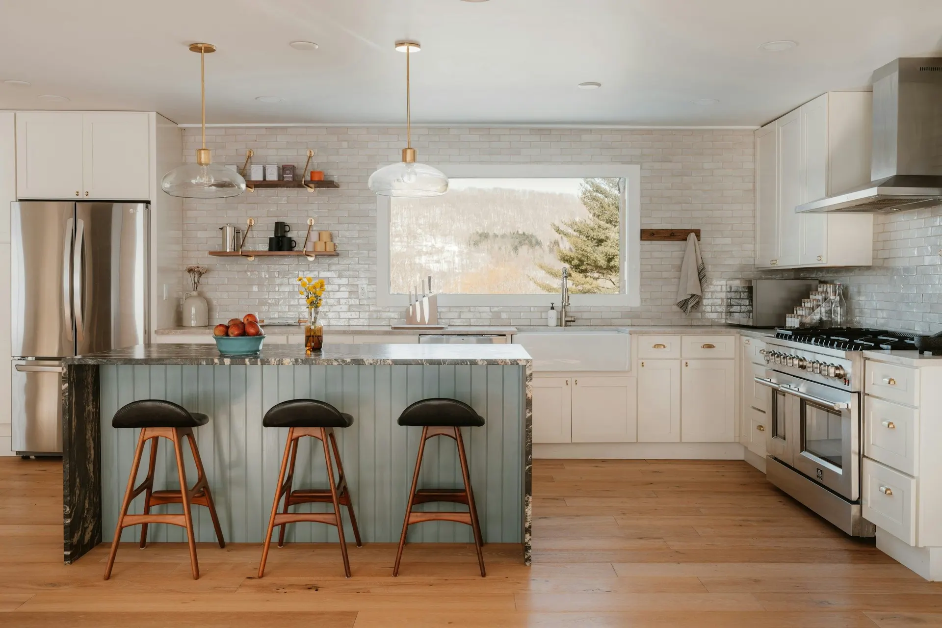 A bright kitchen with white cabinets and a teal island